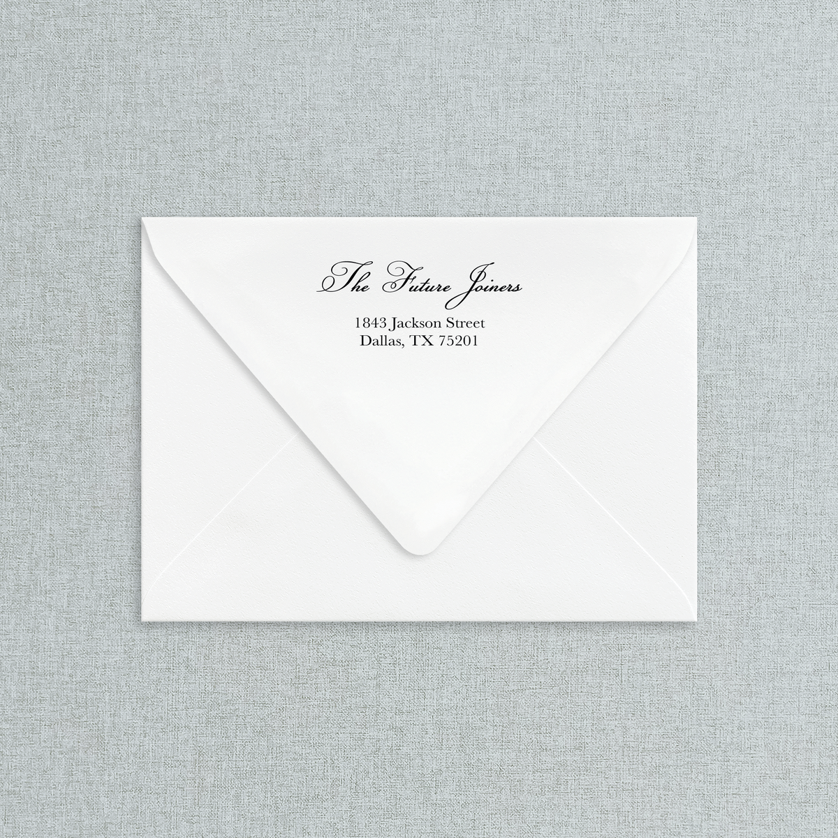 White envelope with black return address on a gray textured background