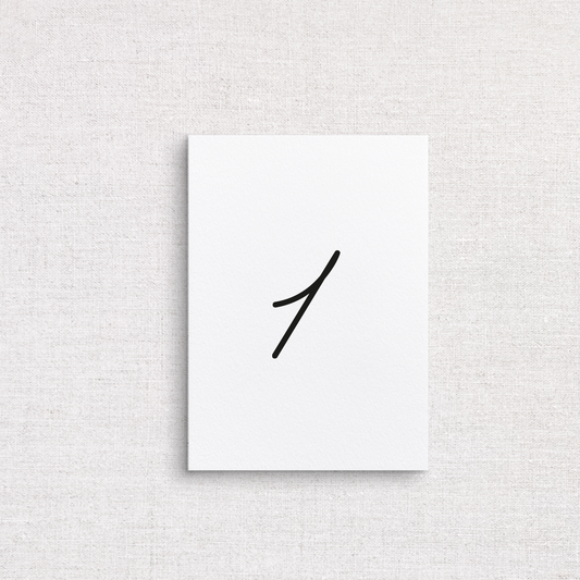 A minimalist wedding table number with single black handwritten numeral '1' in the center, displayed against a textured light beige linen background.