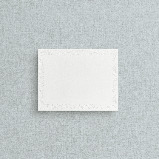 White card with blind deboss letterpress flowers on a textured gray background