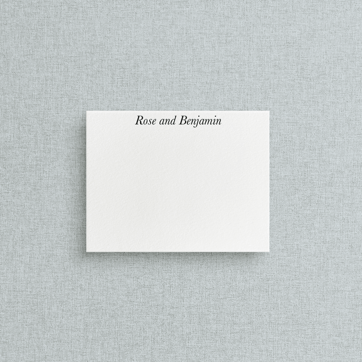 White card with letterpress printing on a gray textured background. 