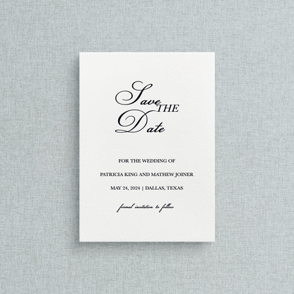 Semi-custom letterpress Save the Date card with black text on a white background, placed on a gray textured surface.
