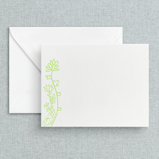 A set of white A2 size stationery cards with sage green floral letterpress designs, accompanied by white envelopes, displayed against a textured background.